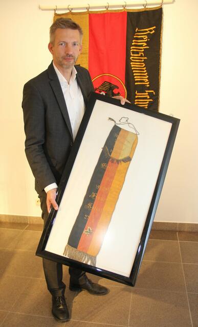 Die Reichsbanner-Ehrenschleife wird Stefan Schmutz an das Mannheimer Stadtarchiv übergeben.