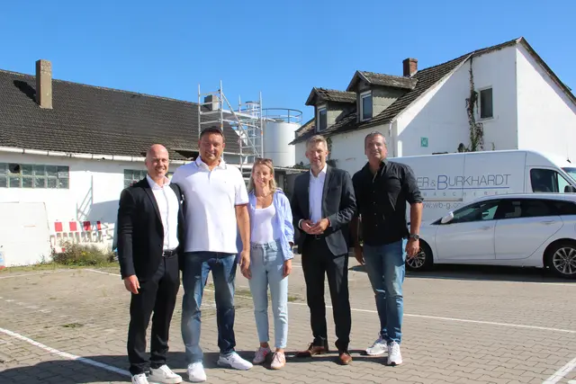 Vor den Gebäuden, die bald abgerissen werden, um dort eine Sporthalle zu bauen, präsentierten Sabrina Burkhardt und Sven Witteler (2. von links) sowie Inanc Karaca (rechts) das Hyrox-Hallen-Konzept. Bürgermeister Schmutz und Christan Stopper von der Volksbank Kurpfalz (links) sind vom Erfolg des Projekts überzeugt.