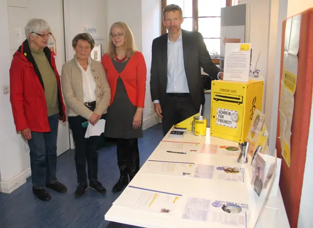 Die ai-Sprecherin Bärbel (2. von links) Luppe und Lilo Trenkel (links) eröffneten im Beisein von Bürgermeister Schmutz und der Leiterin der Stadtbibliothek Yvonne Herrfurth die Briefmarathon-Aktion 2025. 