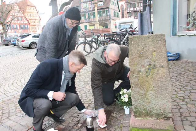 Bürgermeister Stefan Schmutz und Jürgen Frank, der Sprecher des Demokratie-Bündnisses, putzten die Erinnerungstafel am Denkmal für die Opfer der Deportation. 
Hermann Schmölzer begrüßte es, dass an den Holocaust-Gedenktag erinnert wurde.  | Foto: Sturm