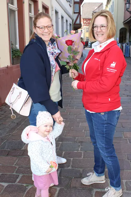 Die Ladenburgerin Eva Walter, die mit ihrem Töchterchen unterwegs ist, freut sich über eine Rose von Kathrin Kern.