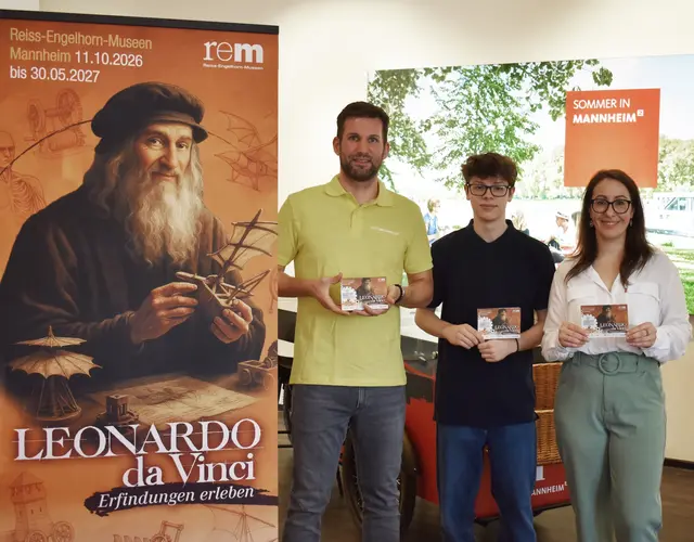 Präsentieren gemeinsam in der Tourist Information Mannheim die neue Faltkarte mit Leonardo-Ausflugstipps: Christian Förster (Leiter Tourist Information Mannheim) sowie Yannick Rosendahl und Giulia Worf (Kuratoren-Team der Leonardo-Ausstellung)  | Foto: © rem gGmbH Stiftungsmuseen, Foto: Norman Schäfer
