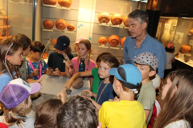 Umringt: Im Keller des Lobdengau-Museums durften die Kinder unter Aufsicht von Andreas Hensen Stücke aus den Vitrinen in die Hand nehmen.